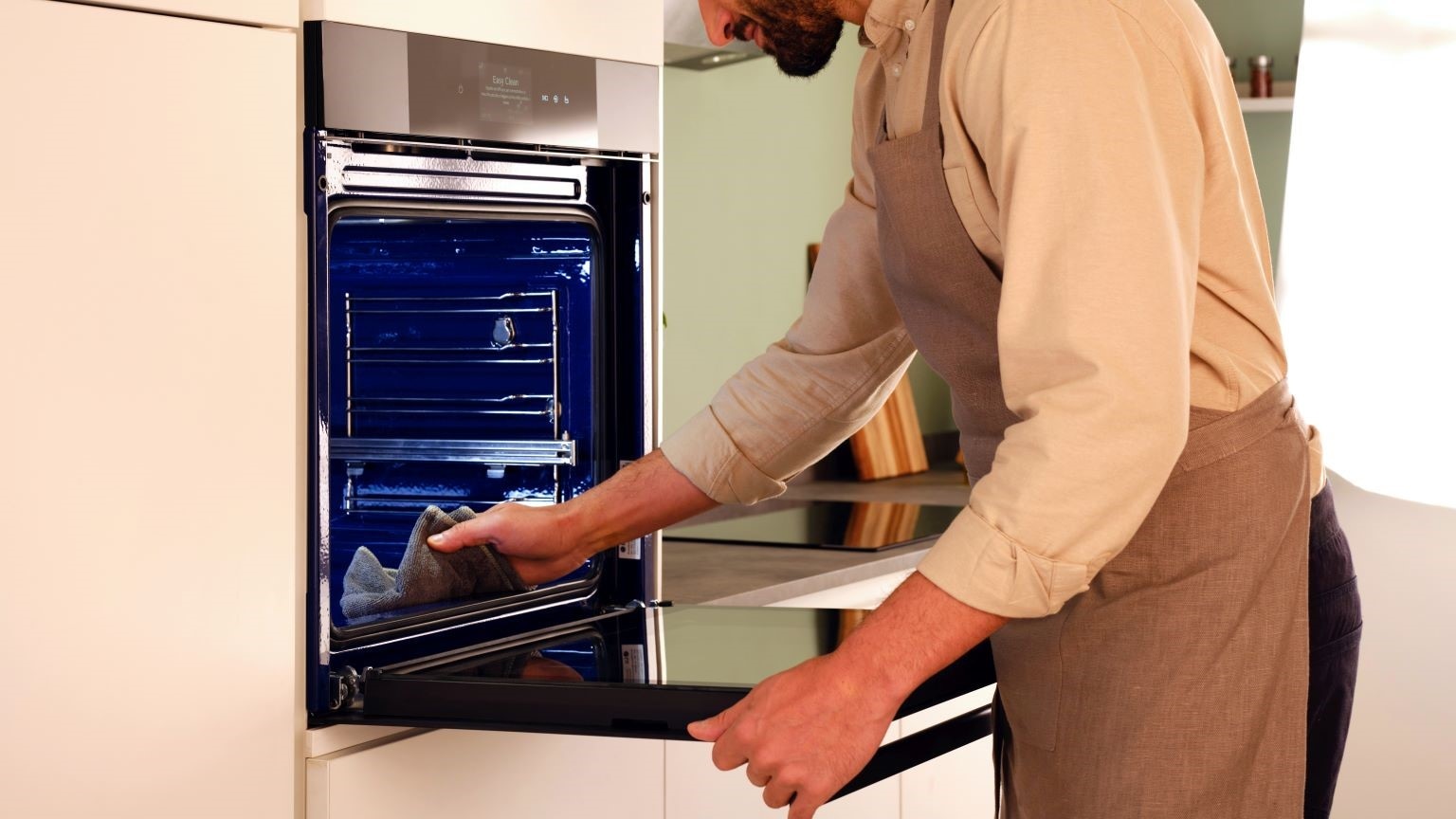 Come pulire il forno in 5 minuti: uomo che pulisce il forno elettrico ventilato intaview di LG