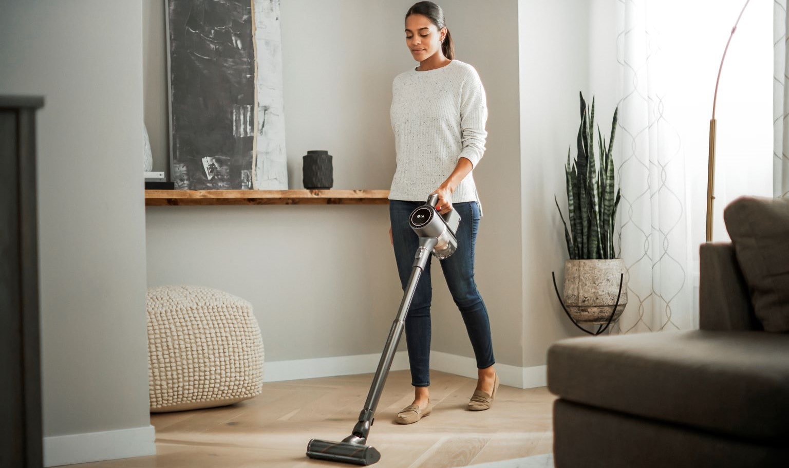 Come tenere casa in ordine senza stress: immagine di una donna che passa l’aspirapolvere LG.