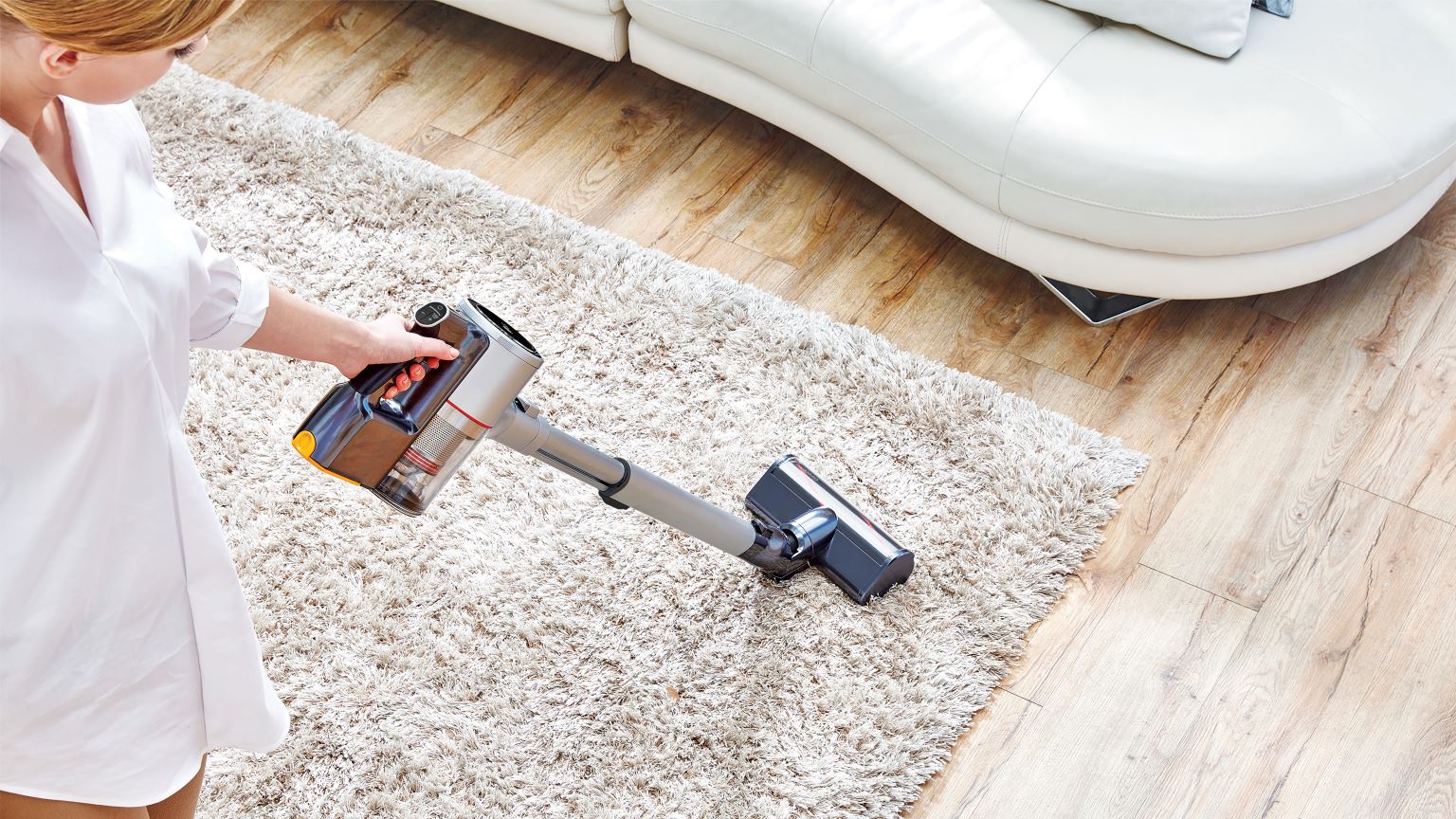 Checklist delle pulizie di primavera: immagine di una donna che pulisce un tappeto con l’aspirapolvere LG.