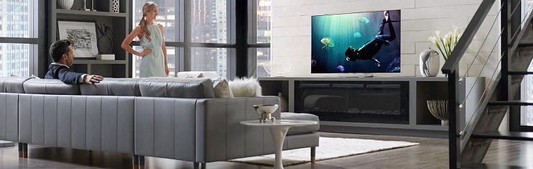 Soggiorno con TV che mostra un musicista e una soundbar, effetti grafici di suono surround visibili.