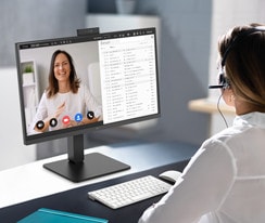 Una donna che indossa le cuffie è in videoconferenza con la webcam integrata.