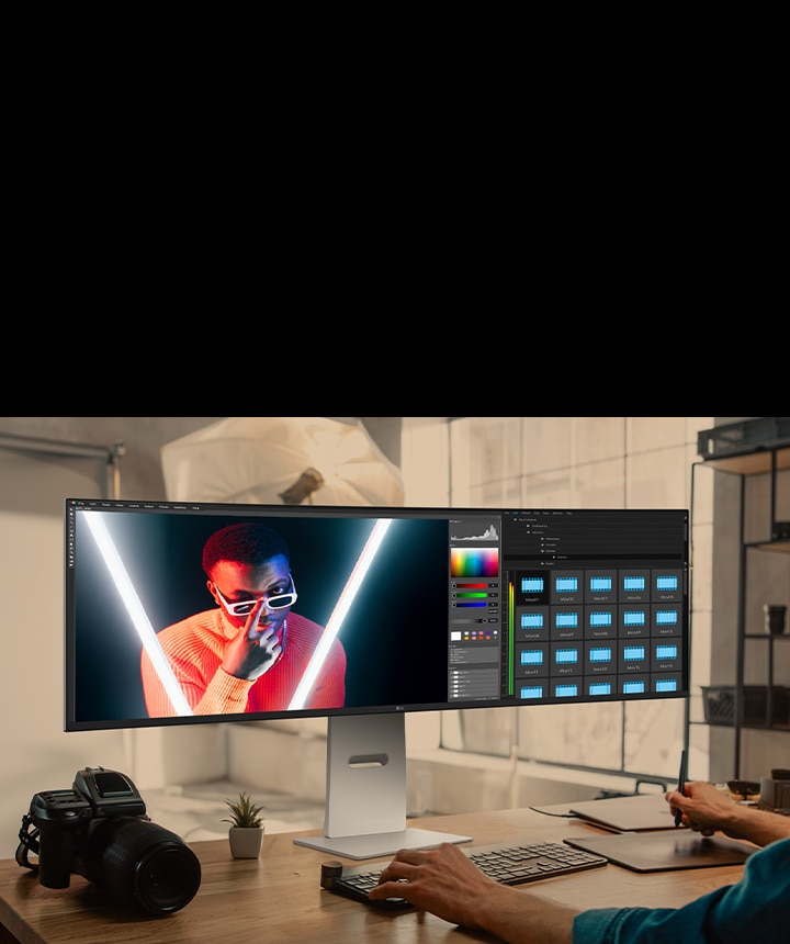 Designer che modifica contenuti visivi sul monitor LG UltraWide, mostrando correzione del colore e progettazione del layout con massima nitidezza.