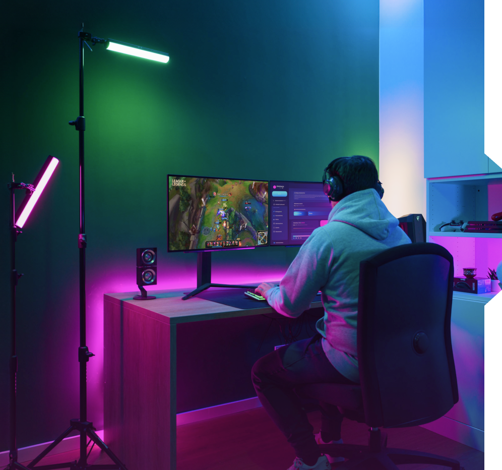 Un giocatore in una stanza buia con luci LED e un setup a doppio monitor.