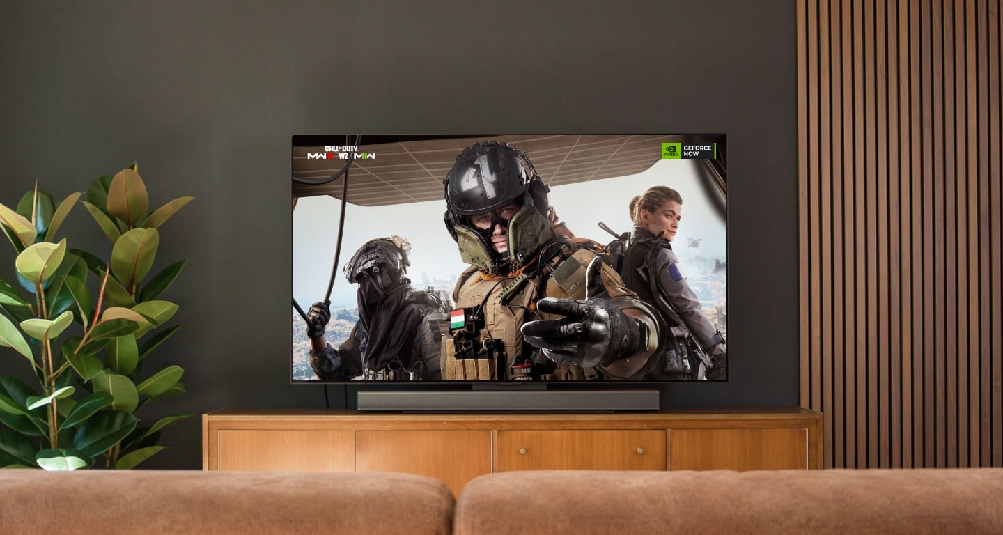 Una grande TV che mostra un gioco con una scena di drago vivace, ambientata in un soggiorno moderno.