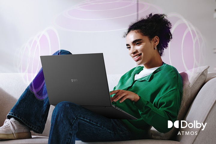 Una persona seduta su un divano, si gode audio coinvolgenti mentre usa un computer portatile LG gram. Il testo mette in risalto la tecnologia Dolby Atmos, che esalta un’esperienza uditiva ricca e coinvolgente a 360 gradi. Lo onde sonore circostanti sullo sfondo rappresentano visivamente il paesaggio sonoro immersivo.