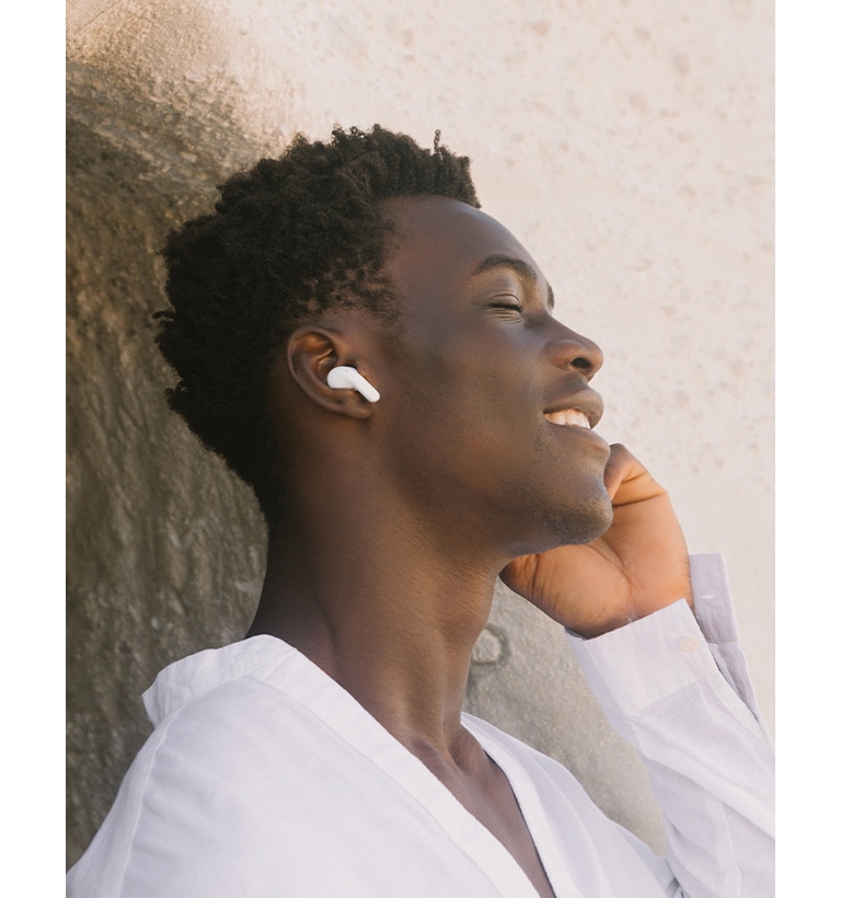 A man is wearing T60 earbuds and listening to music with his eyes closed.