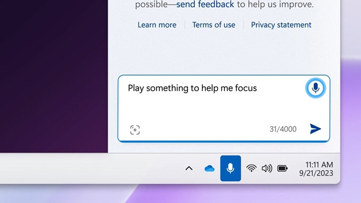 デジタルアシスタントの入力ボックスを示す画像。ユーザーが「Play something to help me focus（集中できる曲をかけて）」と入力している。これはWindowsタスクバーインターフェースの一部である。下には標準システムアイコンが並び、集中できる音楽のリクエストであるということを示している。