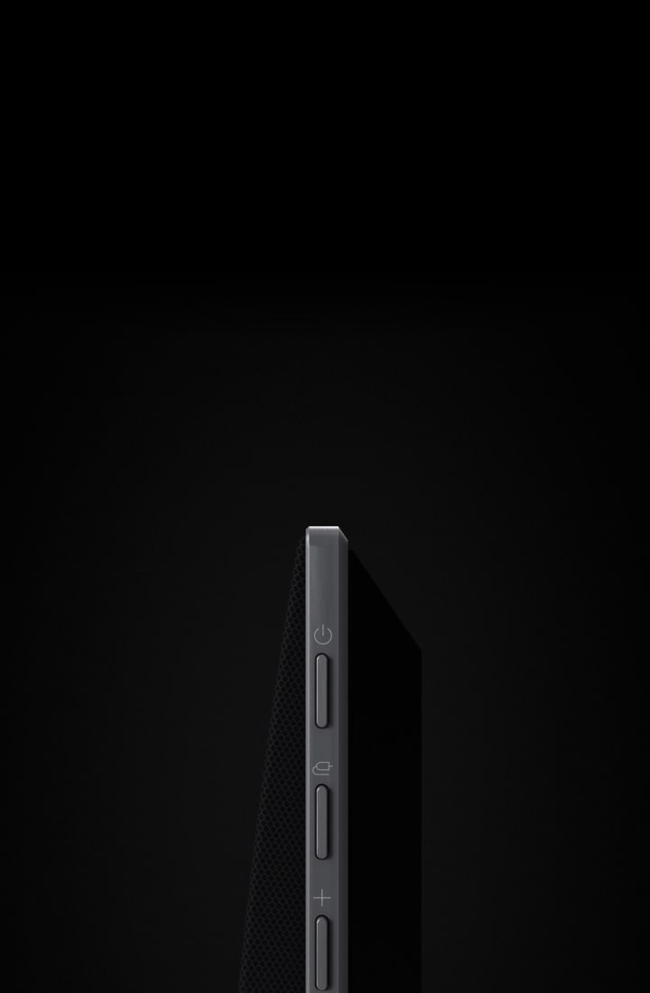 LG Soundbarが、黒い背景の前で開いてSoundbarのサイドボタンを見せ、水平に移動しながら回転してデザインの全体を表示する。黒い背景がLG TVの設置されている壁に変わる。Soundbarもその壁にマウントされている。