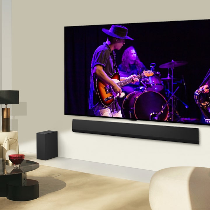 モダンなリビングルームで、LG SoundbarとLG TVが連携して音楽演奏を再生している。