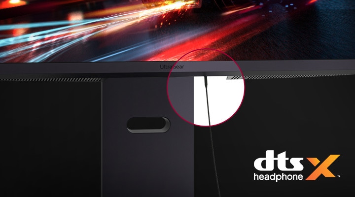 ヘッドホンケーブルを接続したモニタースタンドのクローズアップとDTS Headphone Xのロゴが表示されています。