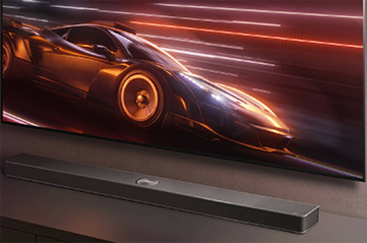 Саундбар LG и телевизор LG TV показаны вместе. На экране отображается игра с гоночным автомобилем.