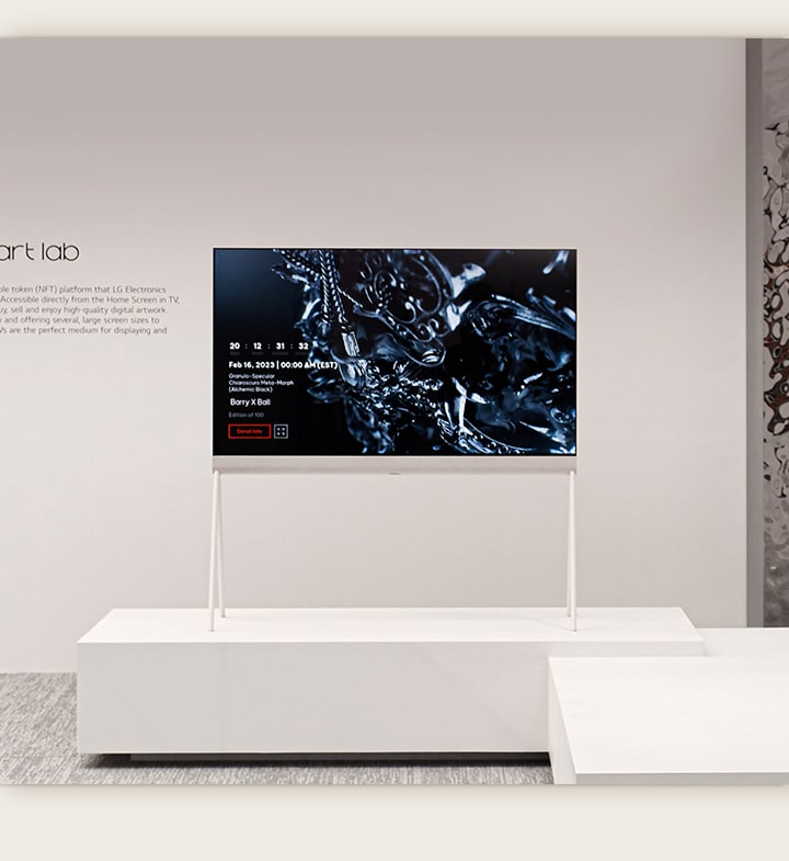 Телевизор LG OLED Easel расположен в белой комнате с цифровой иллюстрацией черной скульптуры на экране. В серебряной физической скульптуре, расположенной справа от телевизора, отражается комната. 
