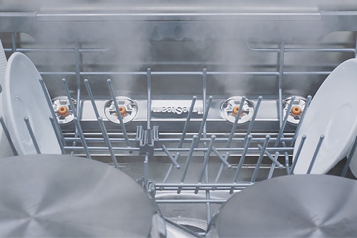 Съемка крупным планом различных видов посуды, проходящей обработку паром в посудомоечной машине.	