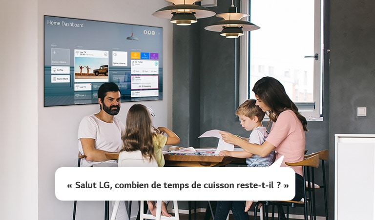 Une famille assise à table dont la mère demande au téléviseur quel temps de cuisson il reste