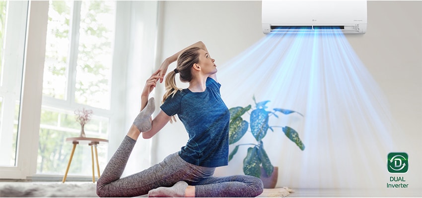 Une femme pratique le yoga sous l'air frais du climatiseur.