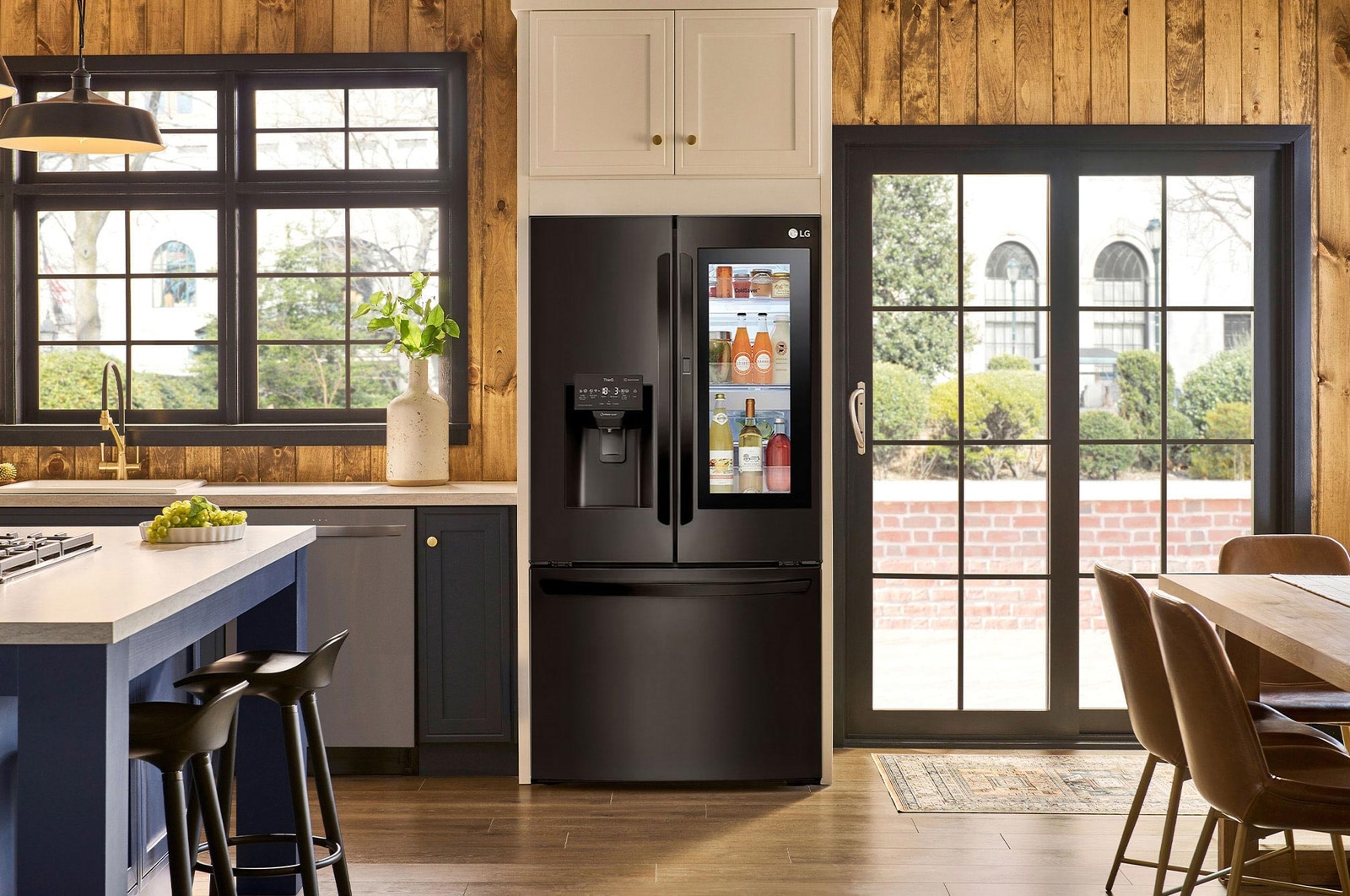 Refrigerador InstaView French Door LG GM28XID Negro Mate, muestra el panel InstaView Door-in-Door iluminado, integrado en una cocina moderna con acentos de madera.