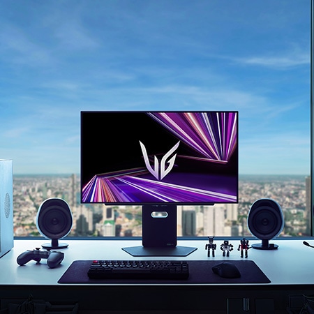 Monitor LG 27GX790A ubicado en el centro de una configuración gaming premium, con un ambiente de habitación oscura con vista a la ciudad y periféricos optimizados para juegos inmersivos.