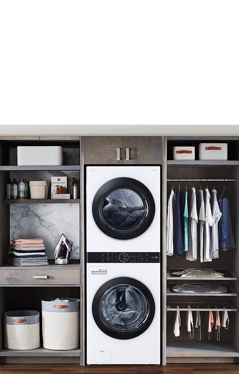 La LG WashTower™ con diseño estilizado maximiza el espacio en una sala de lavado organizada con muebles de almacenamiento.