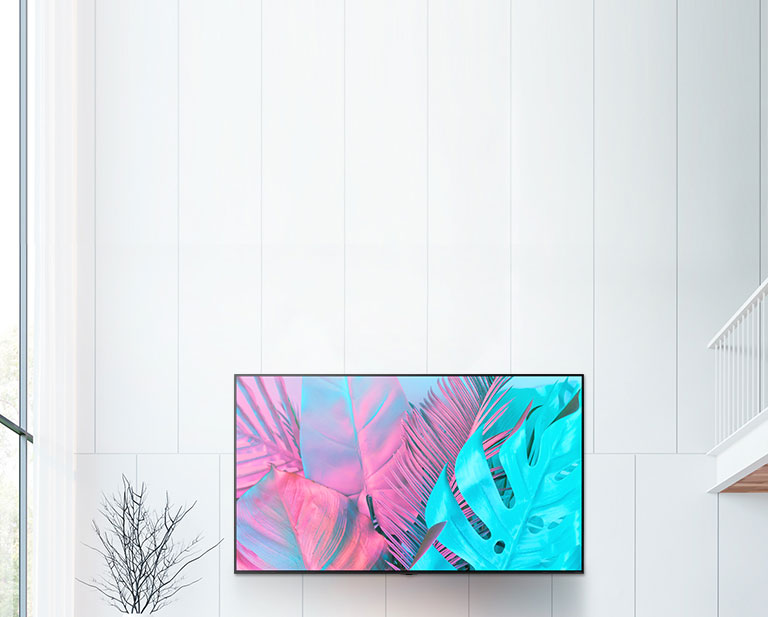 Un televisor de pantalla plana grande montado contra una pared blanca. La pantalla muestra hojas grandes en colores brillantes.