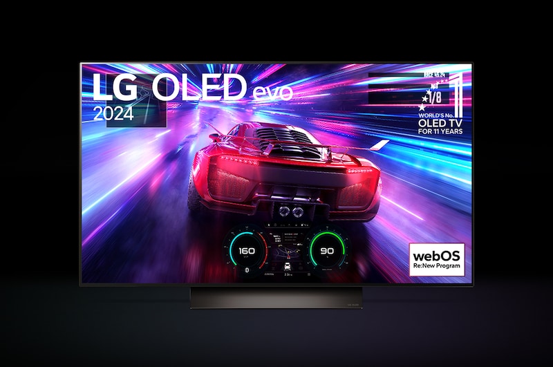 An LG C4 48 inch TV in dark space on a one-pole stand shows a colorful scene of a car racing game, and the colors reflect on the space below.
