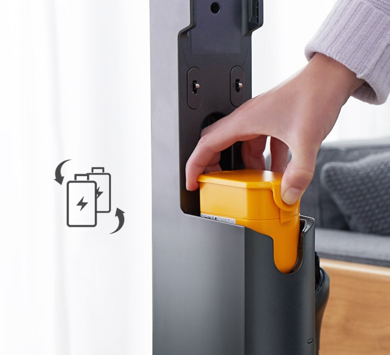 Una mano coloca la batería en la aspiradora. A la izquierda, muestra dos baterías y flechas indicando cambio.