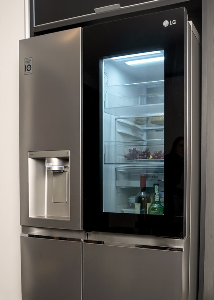 Vista frontal del cuarto de LG InstaView refrigerador en funcionamiento. El color es gris en general y un borde negro de la ventana para el vidrio.