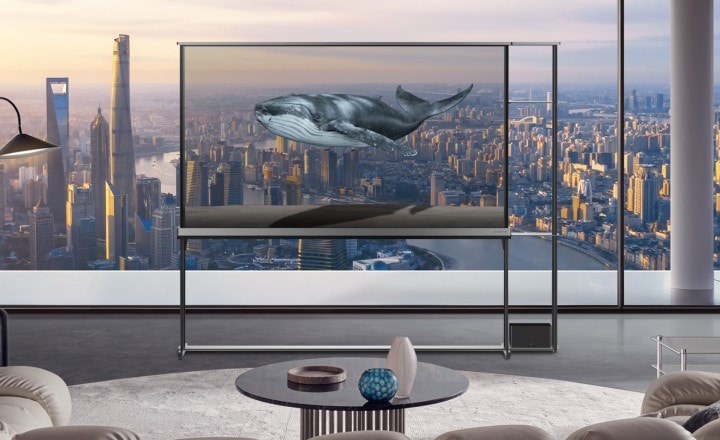 Diferentes escenas que muestran imágenes surrealistas cuando el LG Signature OLED T está en modo transparente. Un paisaje urbano con fuegos artificiales, un pájaro que come algo de un pequeño árbol y peces dentro de un enorme acuario. Todas estas escenas parecen reales, pero se revela que son solo imágenes provenientes de la pantalla del LG Signature OLED T, que se fusionan con el fondo real.