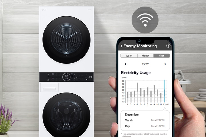 Una lavadora se encuentra en un cuarto de lavado. Una mano que sostiene un teléfono muestra la pantalla a la cámara y la pantalla muestra la información de mantenimiento y el uso de energía con un símbolo de WiFi sobre la pantalla.