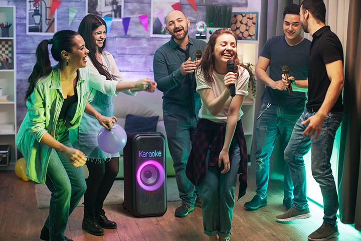 Hay gente disfrutando del karaoke en la sala de estar.