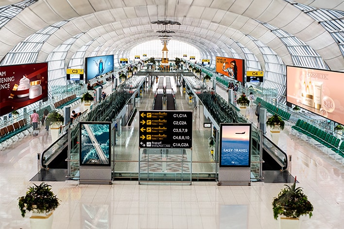 This image captures various content playing on multiple displays inside an airport.