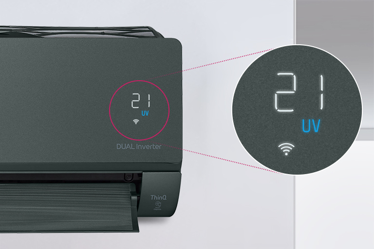 Half of the LG air conditioner can be seen installed on the wall with the front door open indicating it's on. A circle is around the air quality lights of the machine and a magnified circle is extened out to show the green lights of the air quality panel and the numbers to show the precise air quality. The DUAL Inverter logo can be seen on the machine.