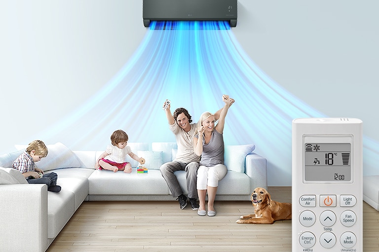 A family sits on a couch in a living room with the LG air conditioner installed above them. Blue lines of air are coming out indicating the machine is on. In the foreground is the front of the remote control showing the buttons and temperature.