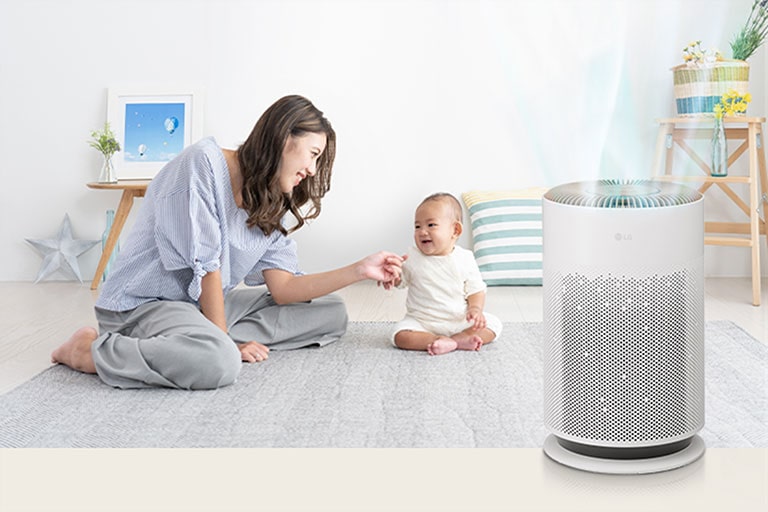 Mom and baby are having a good time in the living room. Clean air is coming out of the air purifier on the right.