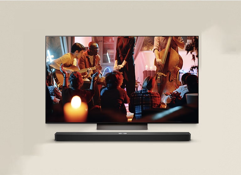 A cozy concert in a living room is playing on the screen. The WOW Interface menu appears as an overlay and the user navigates to soundbar settings.