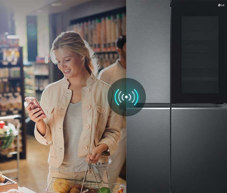 A split screen image of a women in a supermarket with a mobile phone. The woman is communicating with her fridge at home in the kitchen while she is doing the grocery shopping. Above the fridge is a wireless remote icon.