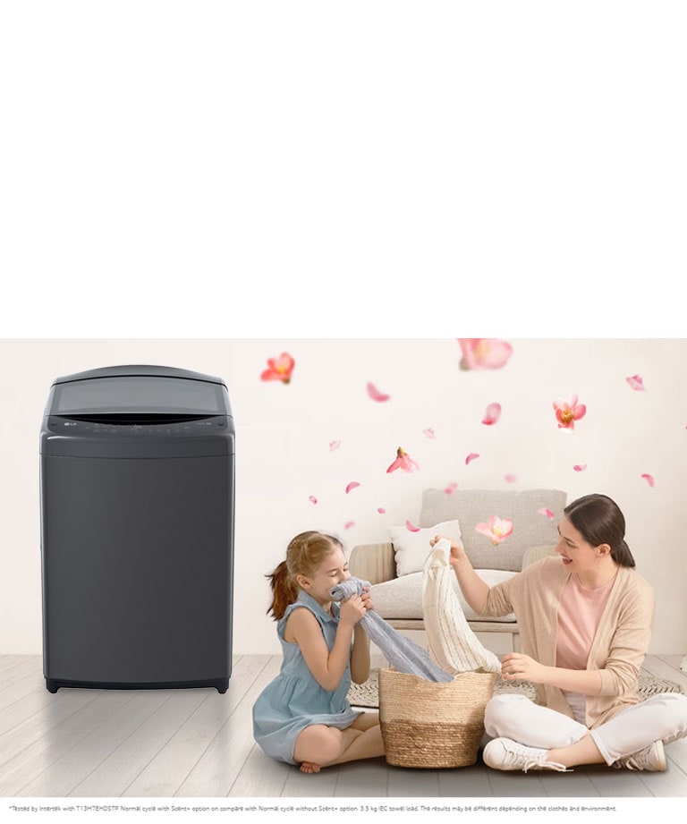 The 'scent' button on the LG washing machine is emphasized, a mother and daughter sit on the floor enjoying the smell of a towel that just came out of the washing machine that sits next to them. Petals are flying around them.