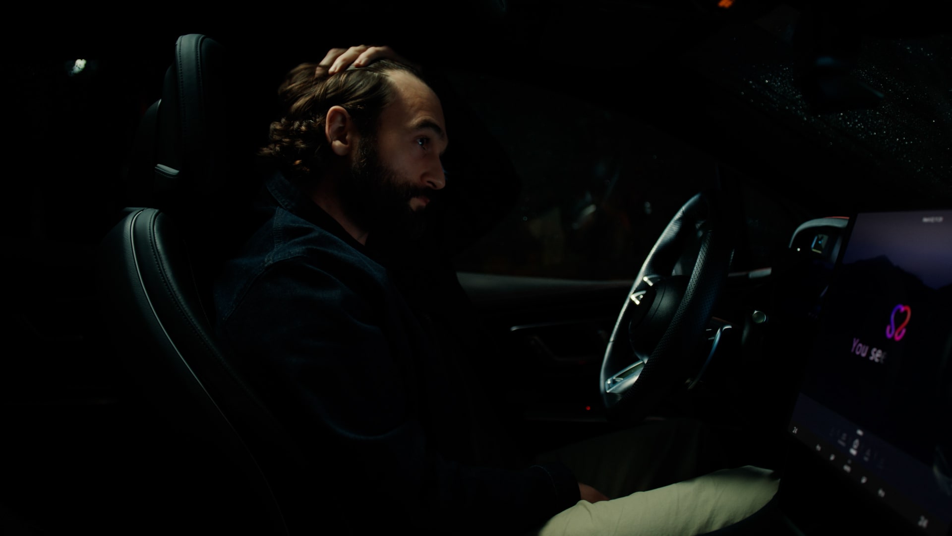 A man is sitting in a car, feeling sad. When the LG AI device shows him a family photo, the man smiles.