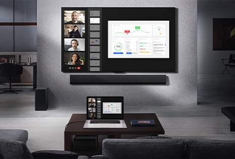 Woonkamer met uitzicht vanaf de bank op een LG True Wireless TV en LG Soundbar die op de wand zijn gemonteerd. Op de salontafel staat een laptop die is verbonden met de Zero Connect Box die nauwelijks te zien is onder de tafel. Het scherm van de laptop, waarop een live videogesprek plaatsvindt, wordt draadloos weergegeven op het tv-scherm. De hele ruimte is netjes en vrij van kabels.