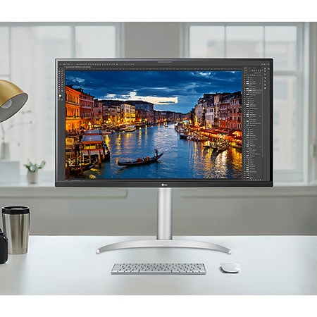 De LG Monitor 32UQ850V-W in zilver/zwart afwerking met 4K UHD en Nano IPS Black beeldkwaliteit, wordt gebruikt voor professionele fotobewerking in een lichte studio-omgeving.
