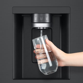 Een persoon krijgt water uit de koelkastdispenser in een beker