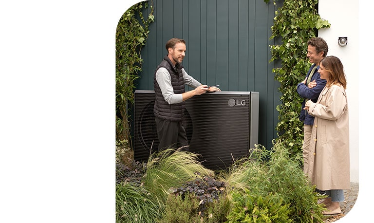 Een technicus staat naast de nieuwe zwartgekleurde THERMA V en praat met een jong stel terwijl hij de LG lucht naar water warmtepomp installeert.