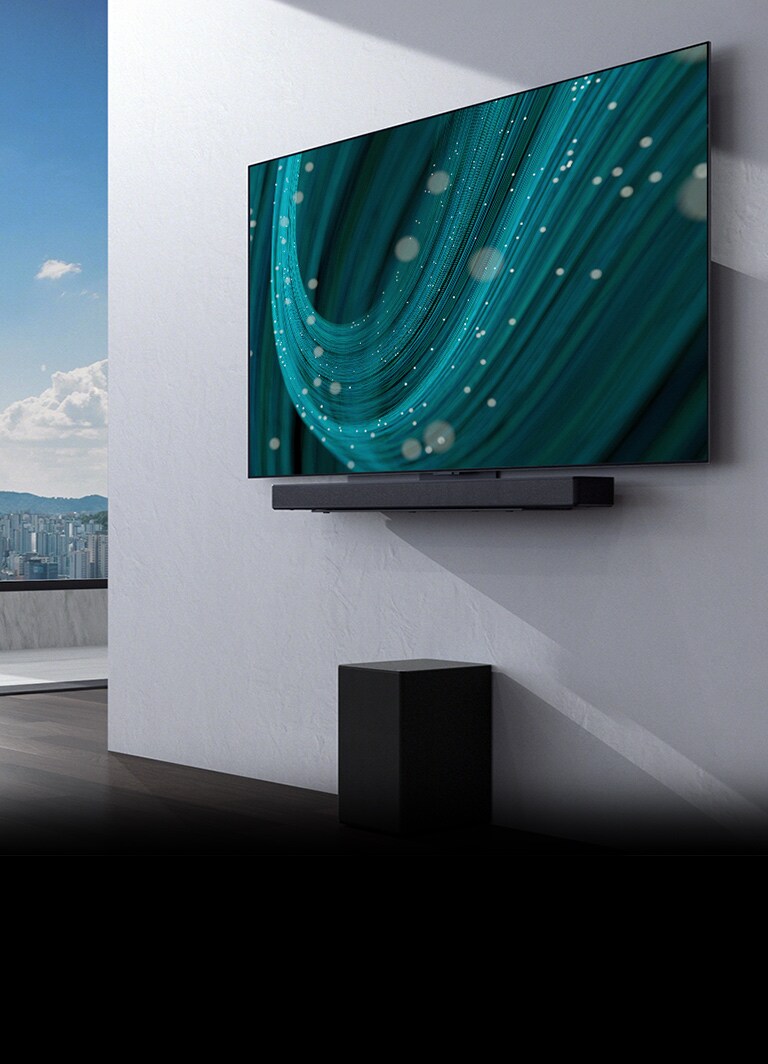 In het midden van een ruimte met een groot raam staat een muur met daarop een tv en een soundbar, met daaronder een subwoofer. Het scherm toont een groenblauwe achtergrondafbeelding.