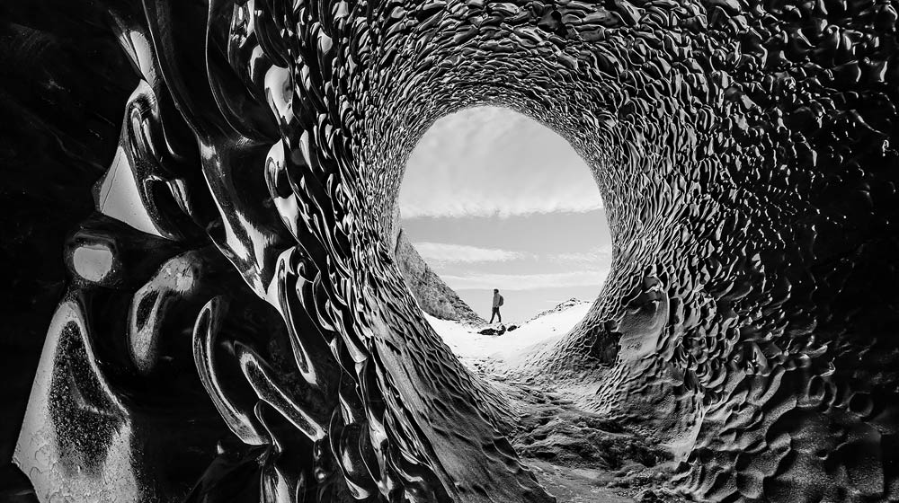 Een video van een man die door een holle tunnel wandelt wordt getoond. Een schuifregelaar beweegt over het scherm en past oneindig contrast toe op het beeld.