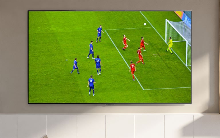 Een tv-scherm waarop een stadion en spelers te zien zijn (speel de video af).