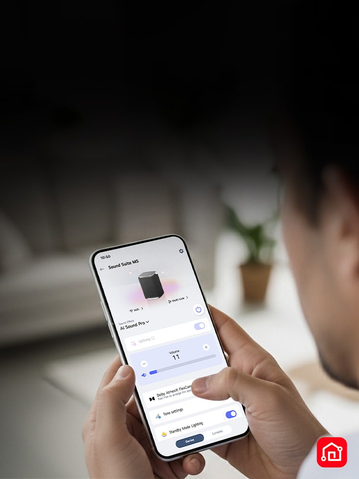 Een persoon die een smartphone vasthoudt met de LG ThinQ-app open, wat eenvoudige bediening van de LG Sound Suite aantoont