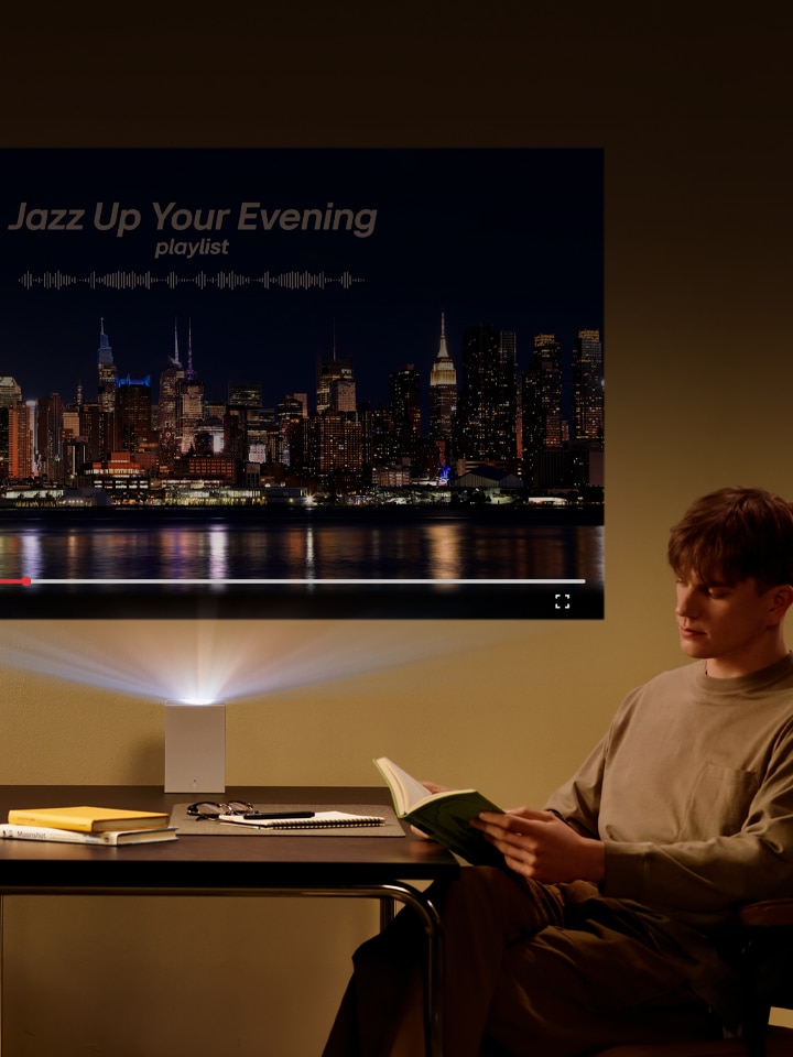 Man leest een boek met LG CineBeam-projectie op de achtergrond.