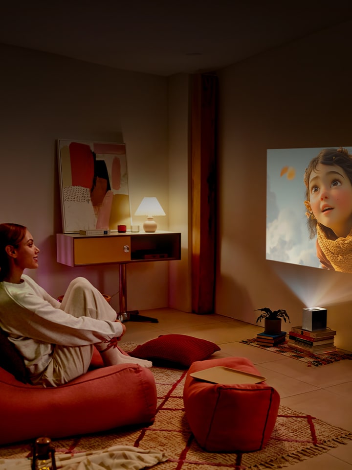 Vrouw kijkt een film met LG CineBeam.