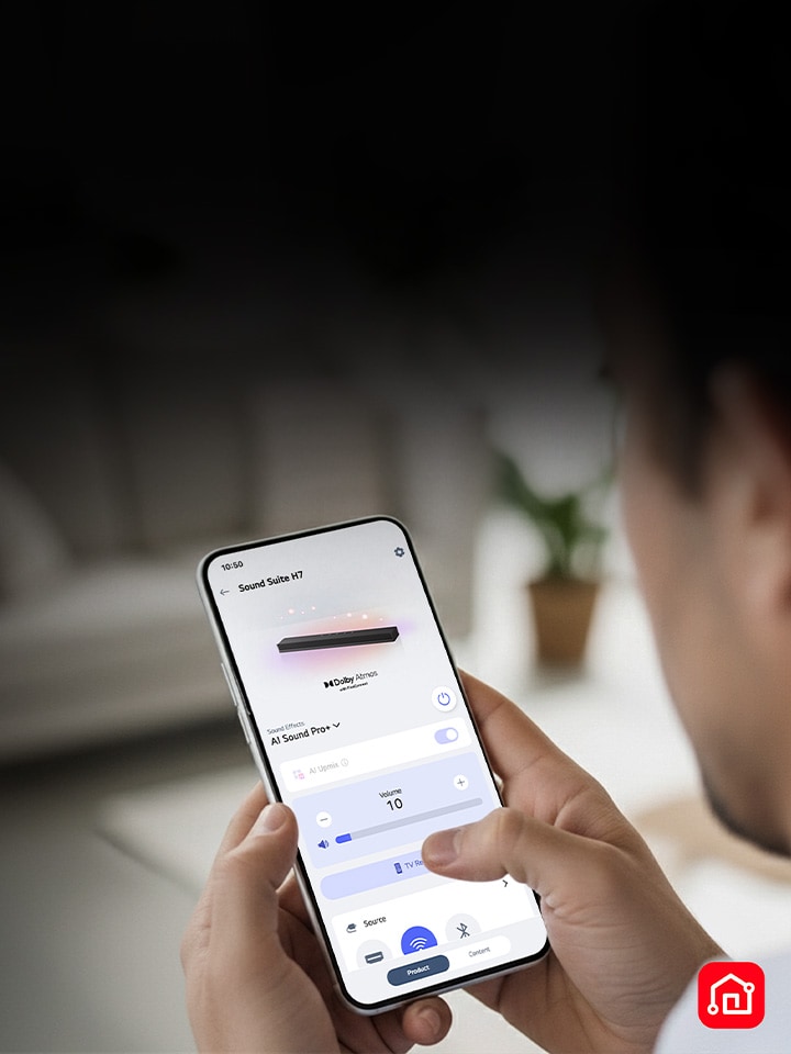 Een persoon die een smartphone vasthoudt met de LG ThinQ-app open, wat eenvoudige bediening van de LG Sound Suite aantoont
