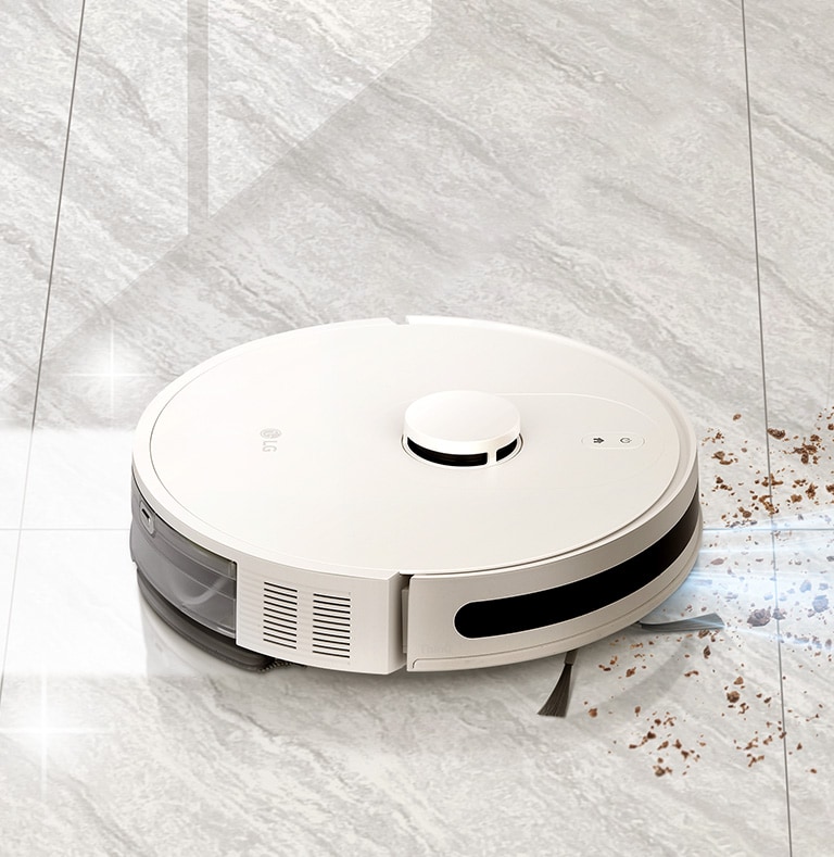 Robot vacuum simultaneously suctioning and mopping a marble floor, with dust in front and a shining floor behind.	