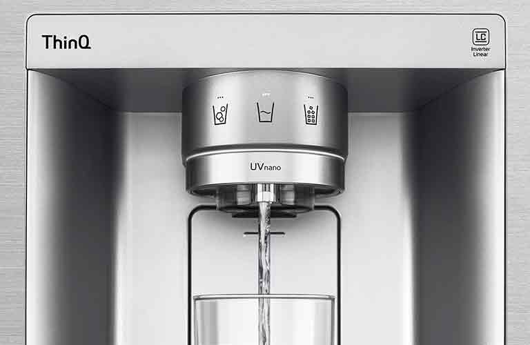 A video/image zoomed in on the water dispenser. The image shows the water droplets as they fall through the UVnano part of the nozzle which reduces the bacteria. The water is being dispensed into a glass.